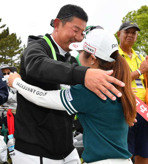 通算11アンダーで優勝した佐久間（右）は、父の浩太郎さんと抱き合う（撮影・岩下翔太）