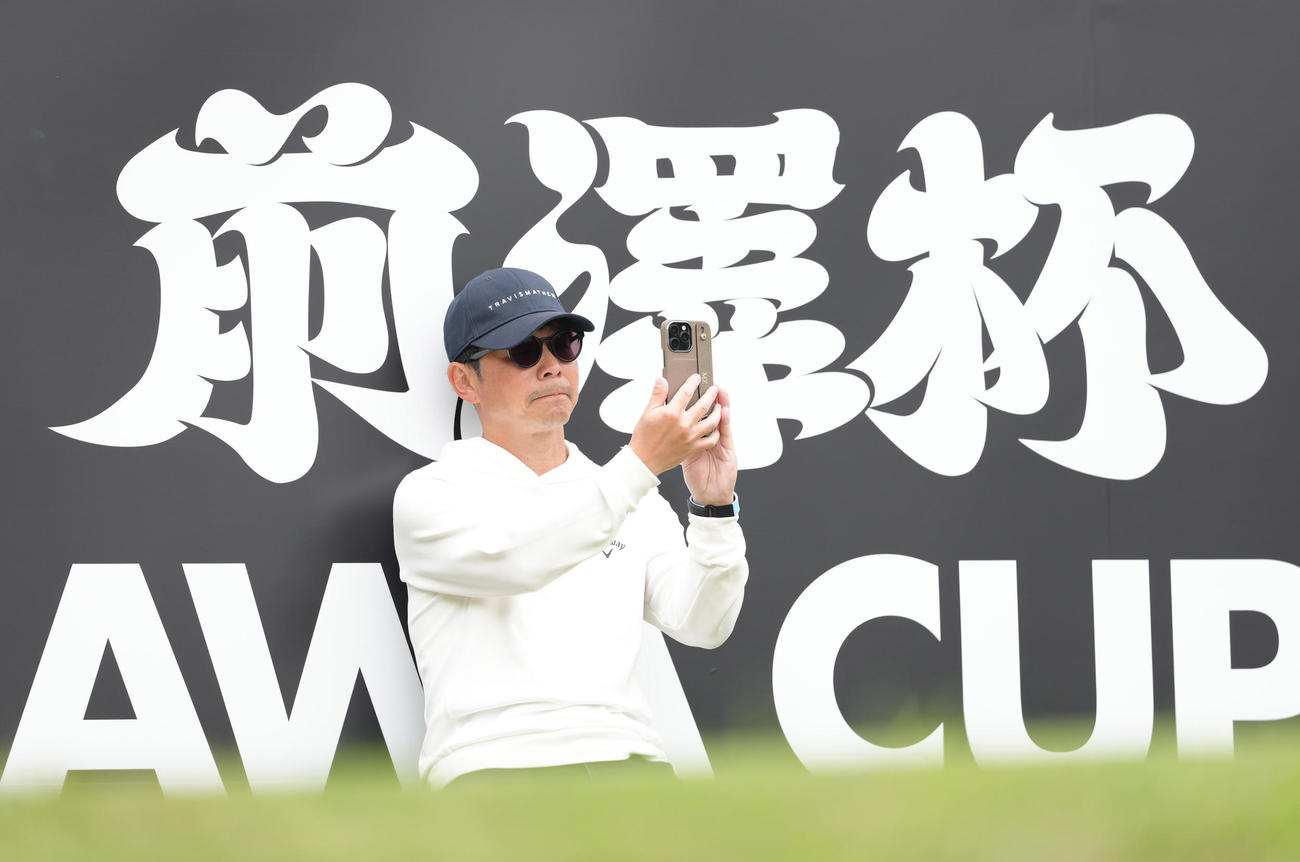 13番、石川遼のティーショットを後方から撮影する前澤氏（撮影・足立雅史）