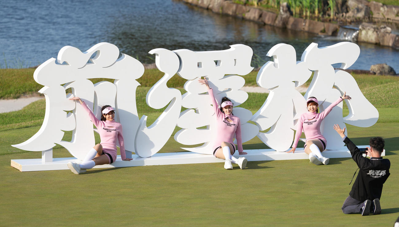 大会を終え、前澤杯の看板の前で記念撮影するラウンドガールたち（撮影・足立雅史）
