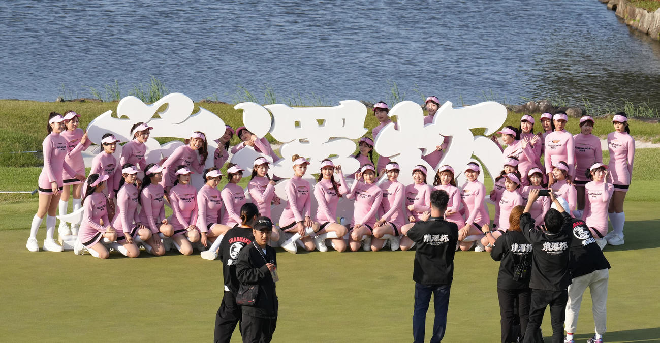 大会を終え、前澤杯の看板の前で記念撮影するラウンドガールたち（撮影・足立雅史）