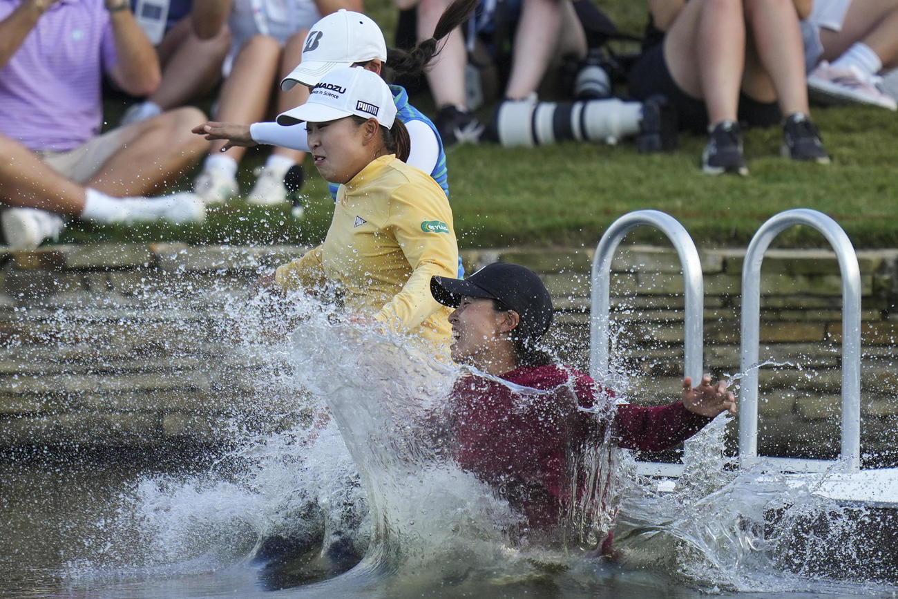 シェブロン選手権で優勝し、池へのウイニングダイブをする西郷真央（中央）（AP）