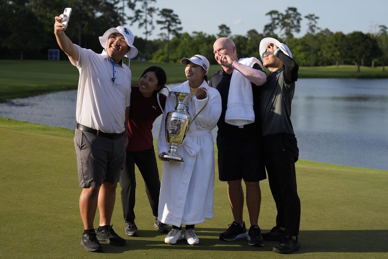 シェブロン選手権で優勝し、池へのウイニングダイブ後、チャンピオンシップ・ローブを着てチームメートと喜ぶ西郷真央（中央）（AP）