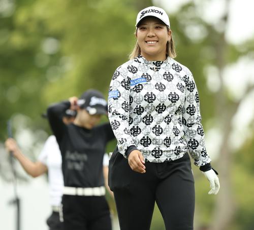 1番、ティーショット後に笑顔で移動する仁井（撮影・河田真司）