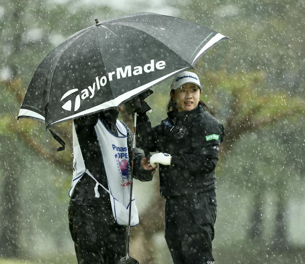 2番、雨が強まり日傘に入る泉田（撮影・河田真司）