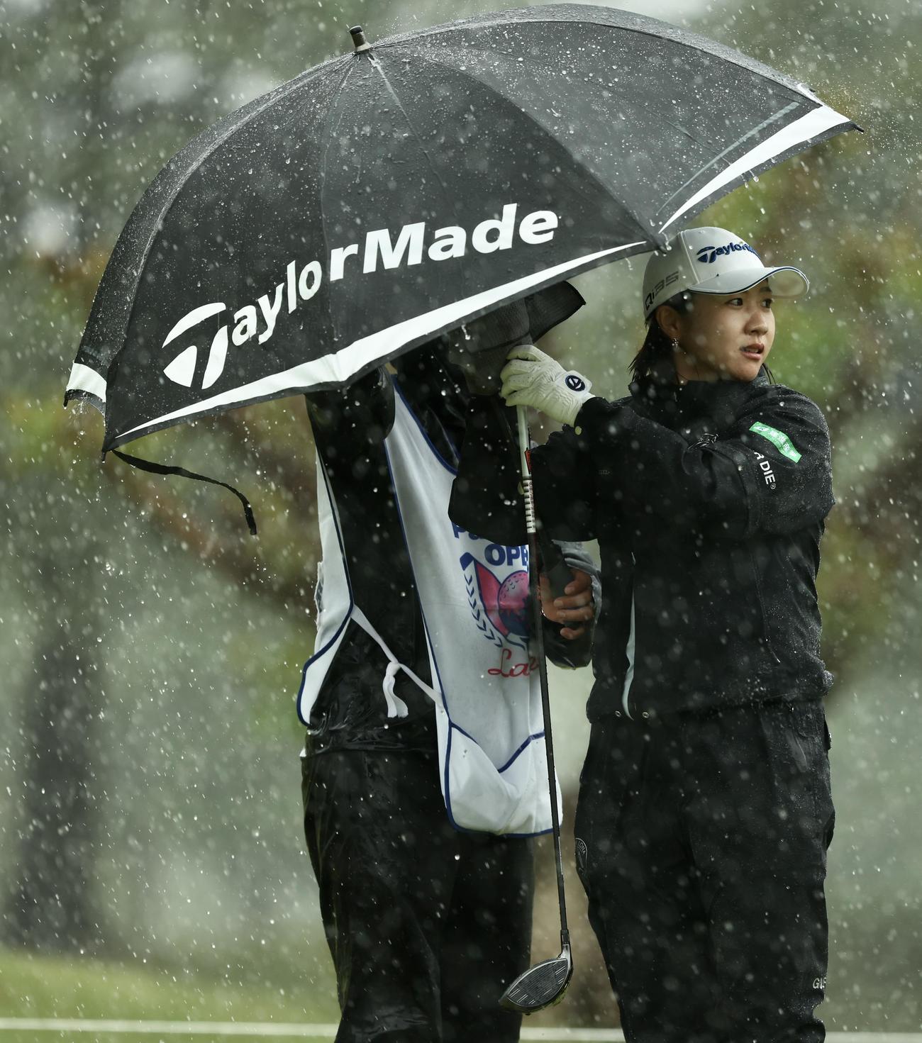 2番、雨が強まり日傘に入る泉田（撮影・河田真司）