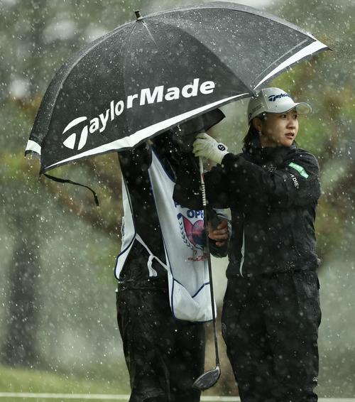2番、雨が強まり日傘に入る泉田（撮影・河田真司）