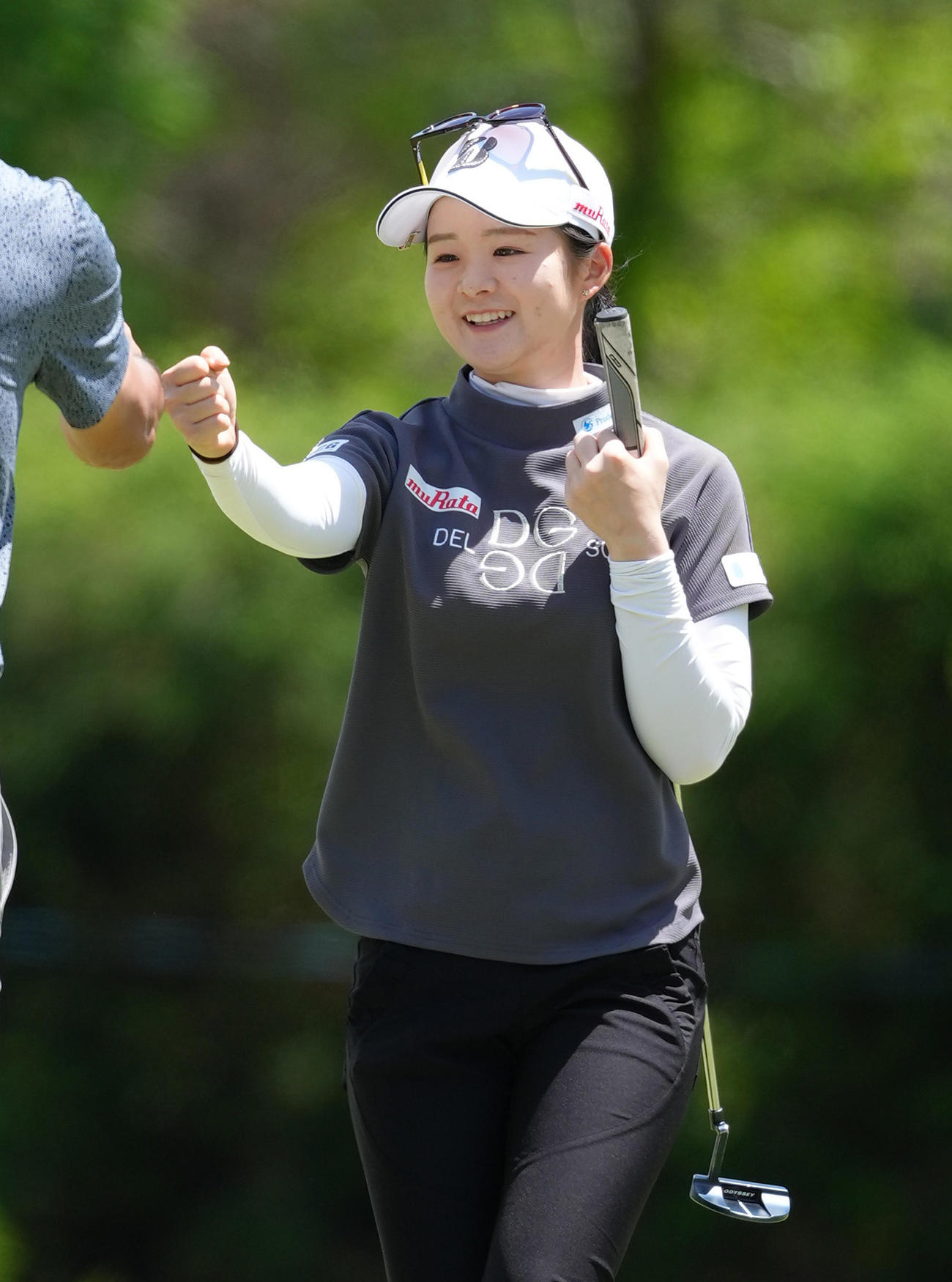 プロアマ戦で同伴者と笑顔でタッチを交わす川崎（撮影・足立雅史）