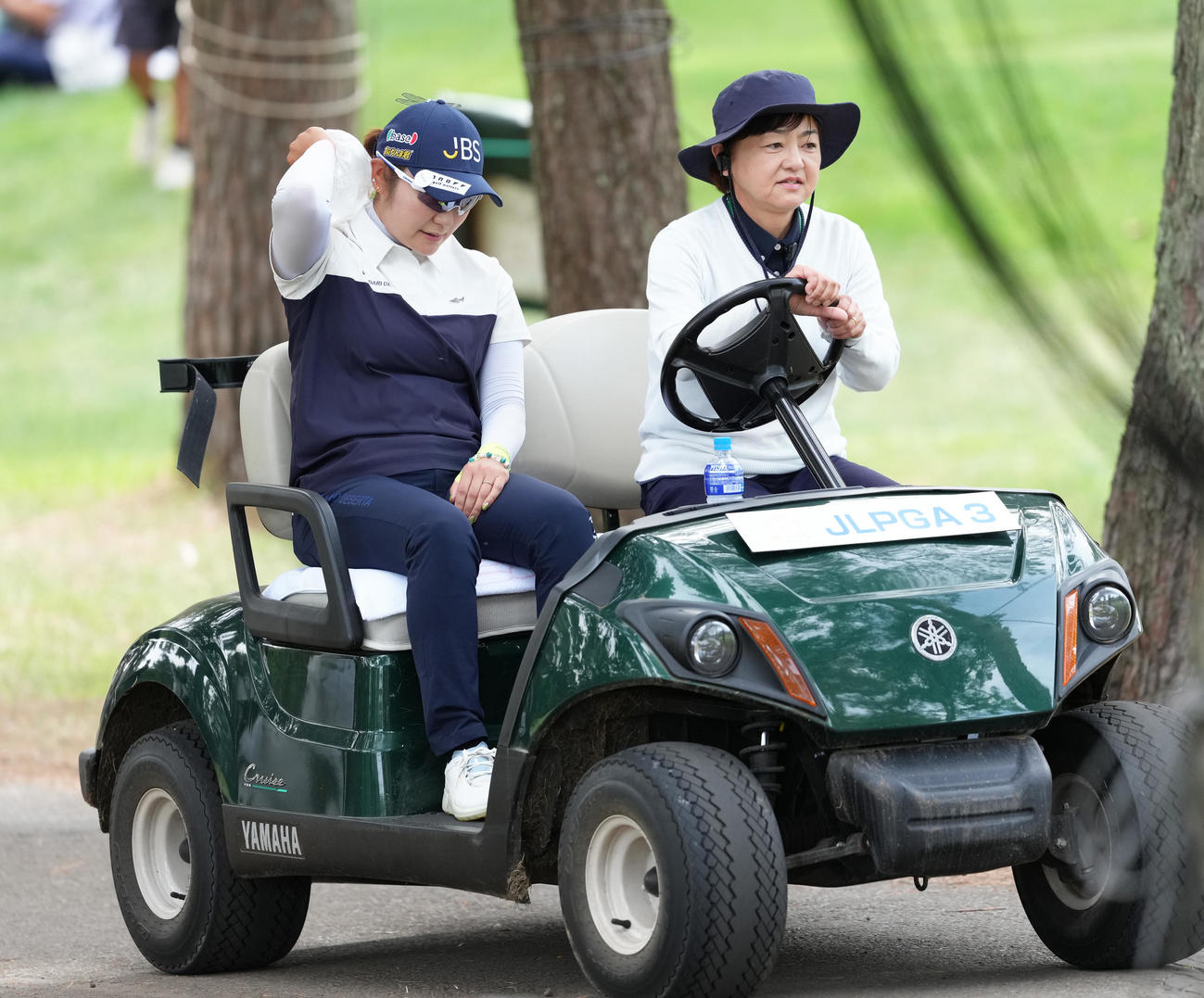 プレーオフに臨む藤田さ（左）は氷のうを首筋に当てながらカートで移動する（撮影・足立雅史）