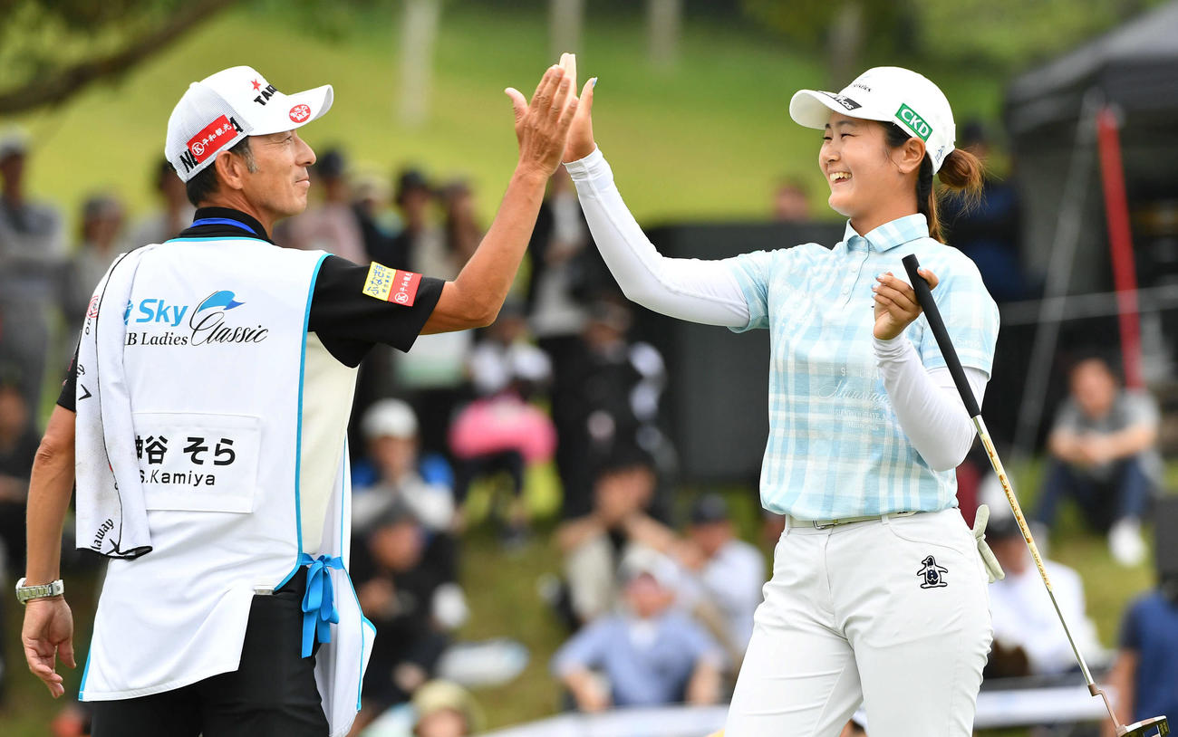 18番、逆転優勝となるイーグルパットを決め、キャディーと笑顔でハイタッチする神谷（撮影・岩下翔太）