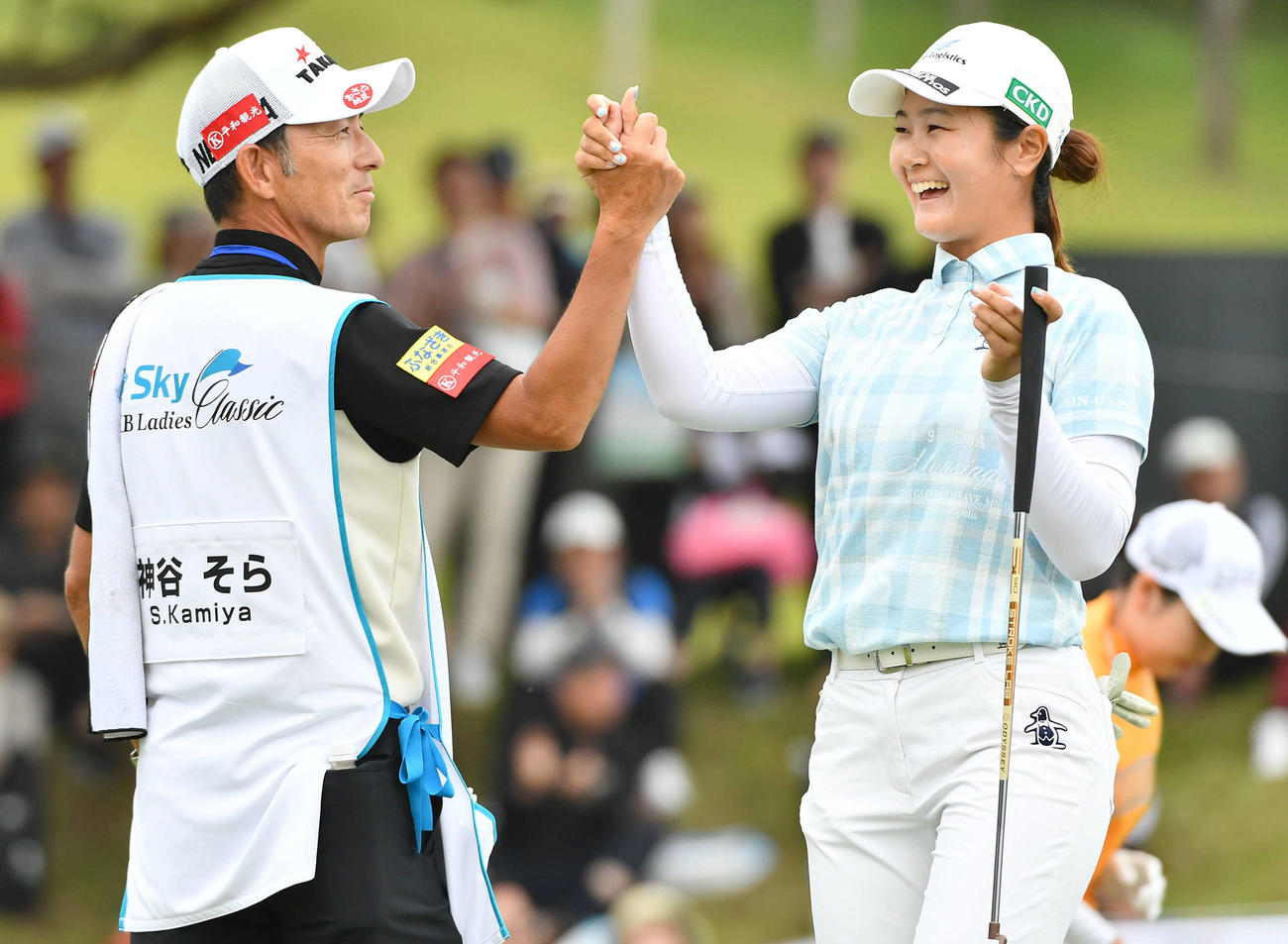 18番、逆転優勝となるイーグルパットを決め、キャディーと笑顔で握手を交わす神谷（撮影・岩下翔太）