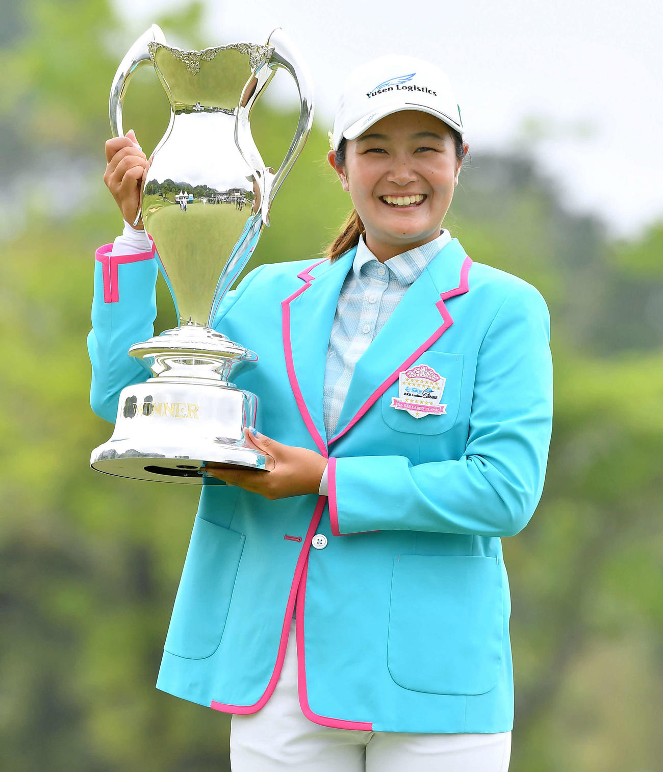 通算14アンダーで優勝し、笑顔で優勝カップを掲げる神谷（撮影・岩下翔太）