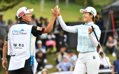 18番、逆転優勝となるイーグルパットを決め、キャディーと笑顔でハイタッチする神谷（撮影・岩下翔太）