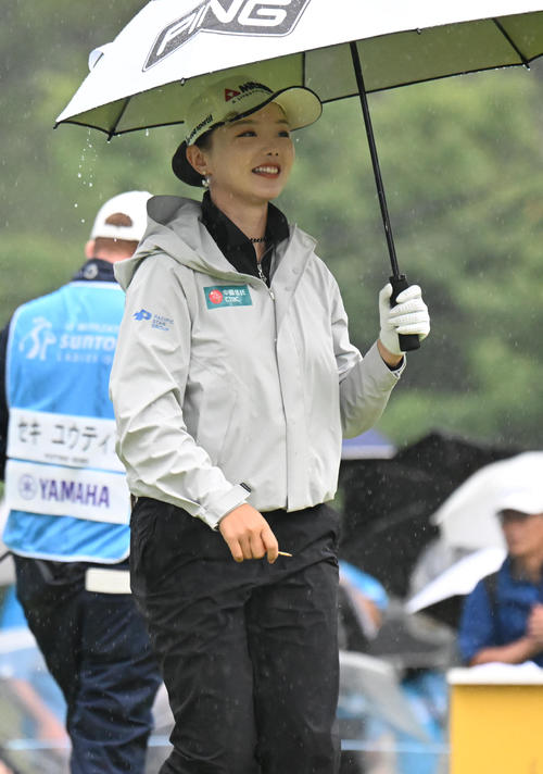1番、ティーショット後、傘を差してスタートするセキ・ユウティン（撮影・和賀正仁）