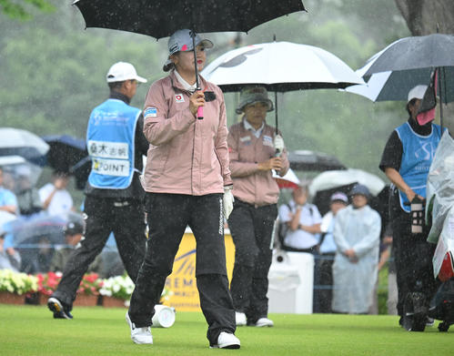 1番、ティーショット後、傘を差してスタートする桑木志帆（撮影・和賀正仁）