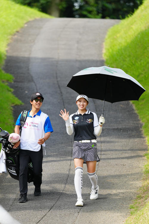 12番へ向かう手束（右）は笑顔で手を振る（撮影・江口和貴）