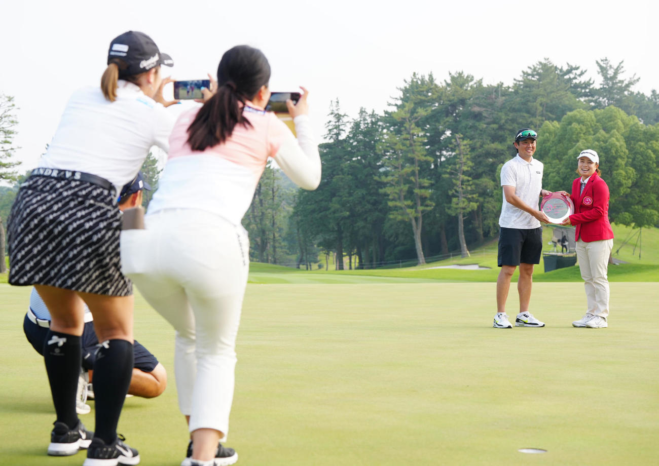資生堂・JALレディースで優勝し、堀（手前右）、安田彩（同左）らが撮影する中、笑顔を見せる永峰（後方右）。同左は夫の田野聖和さん（撮影・江口和貴）