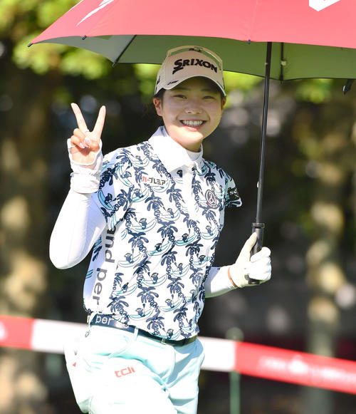 10番、カメラに笑顔でピースサインを見せながら第2打へ向かう菅楓華（撮影・岩下翔太）