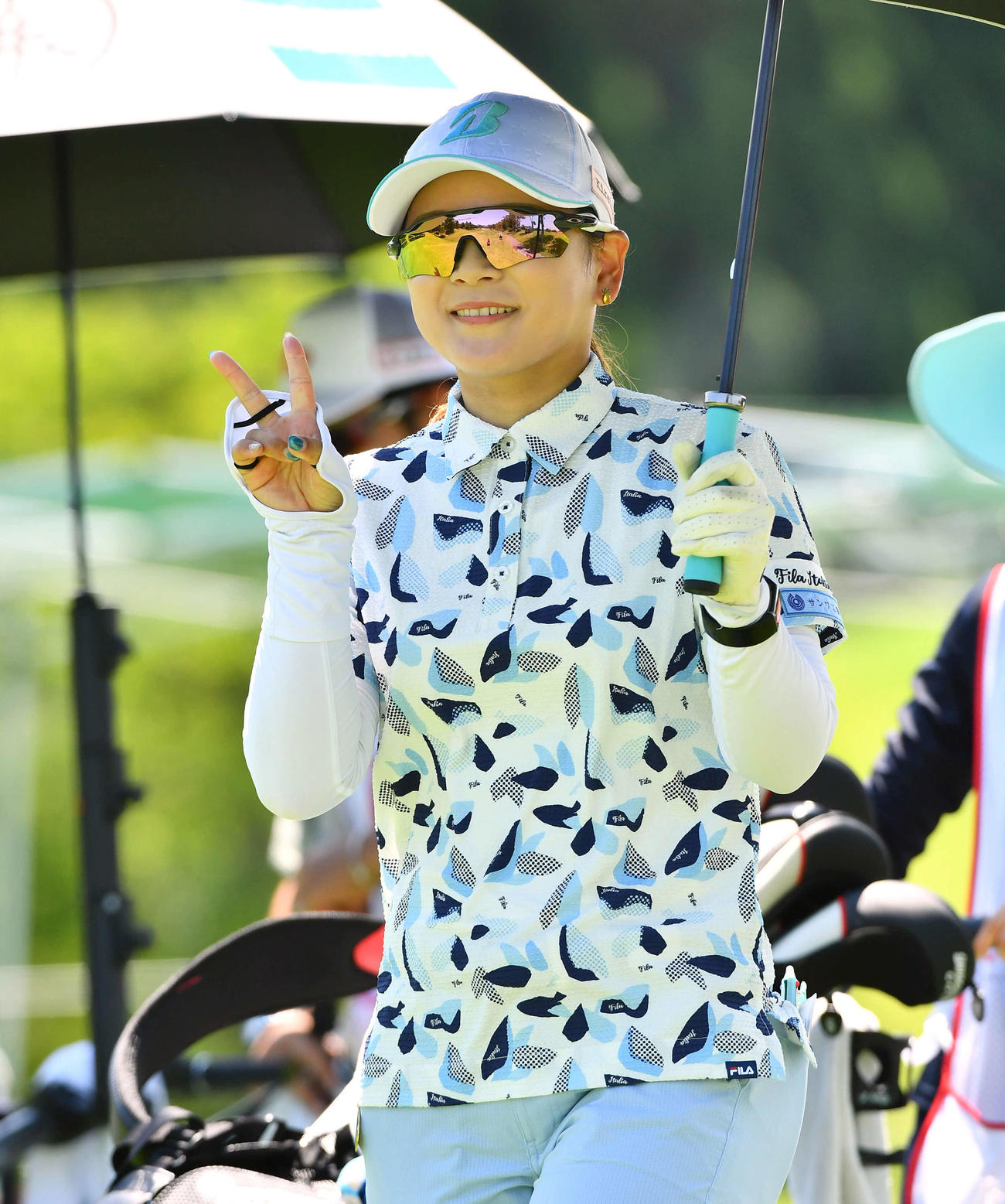 14番、カメラに笑顔でピースサインを見せながら第2打へ向かう古家翔香（撮影・岩下翔太）