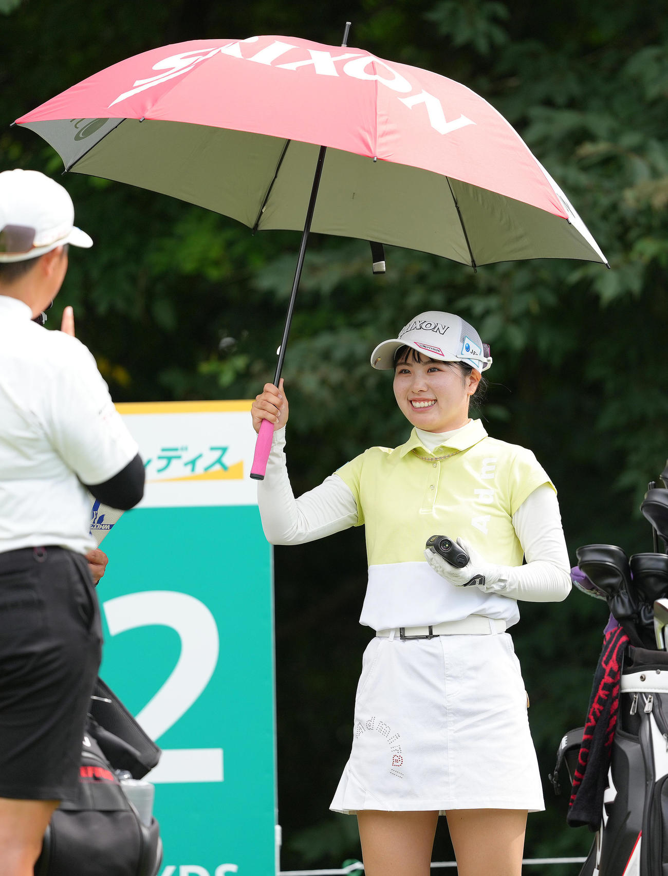 日傘を手に笑顔を見せる尾関（撮影・足立雅史）