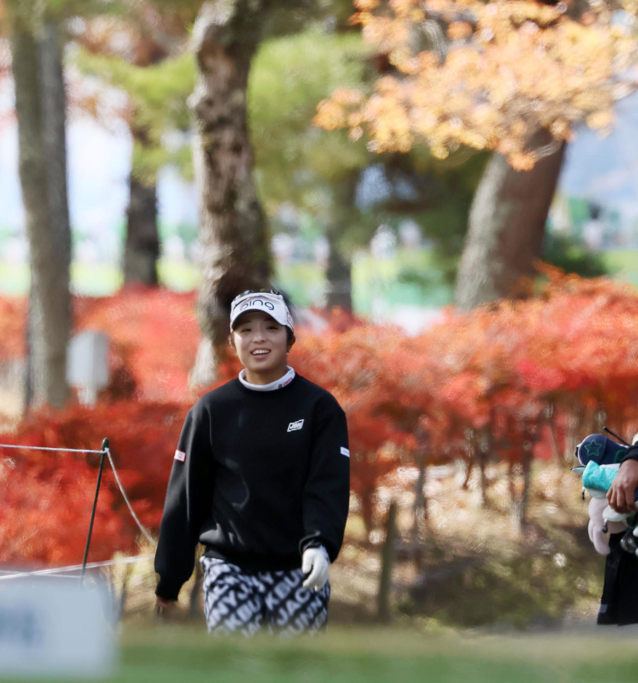 17番、紅葉を背にティーグラウンドへ向かう佐久間（撮影・加藤哉）