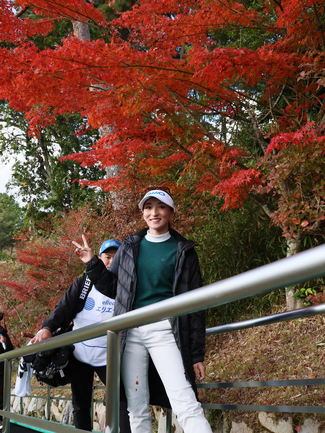 9番を終え紅葉を背に手を振って移動する脇元（撮影・加藤哉）