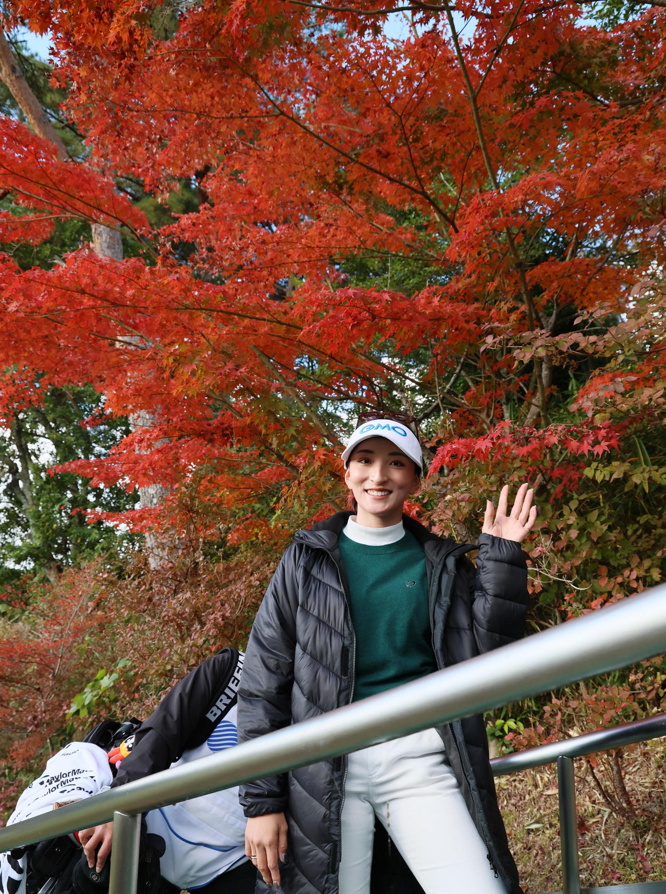 9番を終え紅葉を背に手を振って移動する脇元（撮影・加藤哉）