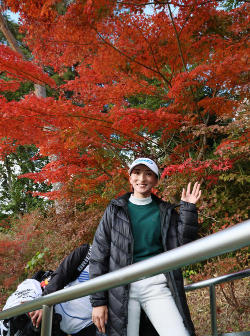 9番を終え紅葉を背に手を振って移動する脇元（撮影・加藤哉）