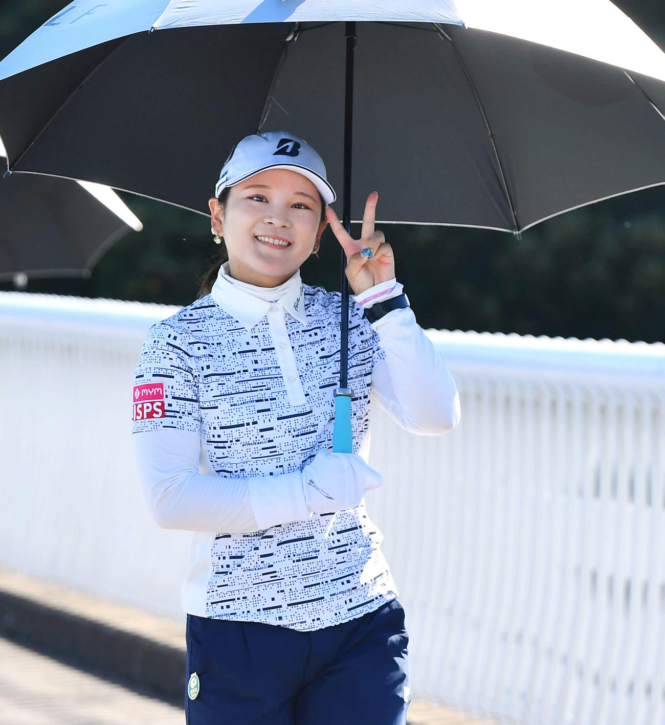 7番へ向かう橋でカメラに笑顔でピースサインを見せる古家翔香（撮影・岩下翔太）
