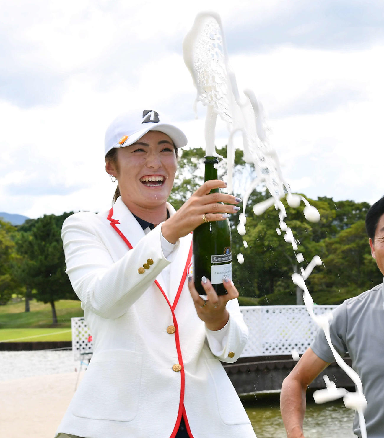通算17アンダーで優勝した渡辺彩香は噴き出すシャンパンを手に笑顔を見せる（撮影・岩下翔太）