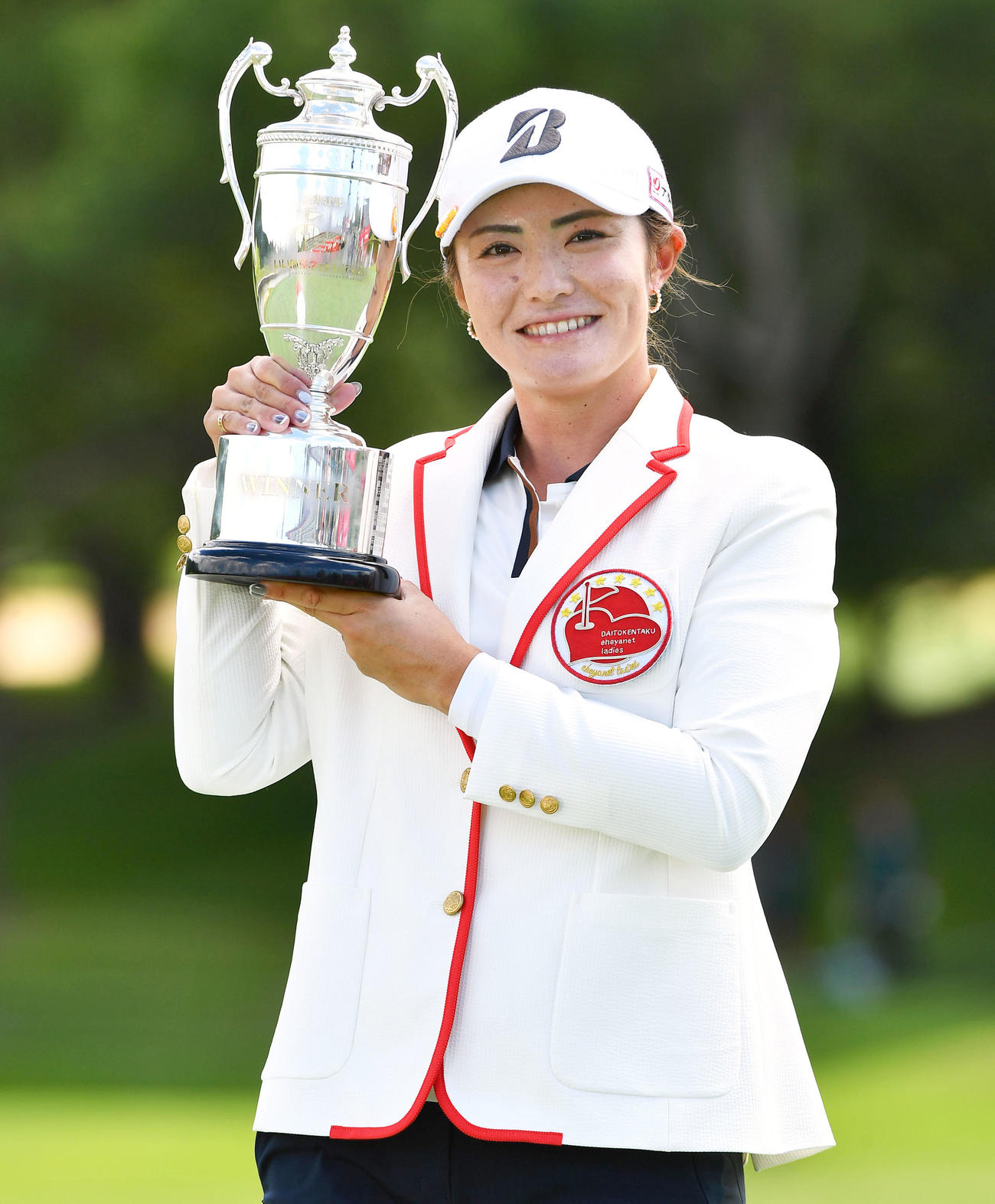 通算17アンダーで優勝し、笑顔で優勝カップを掲げる渡辺彩香（撮影・岩下翔太）