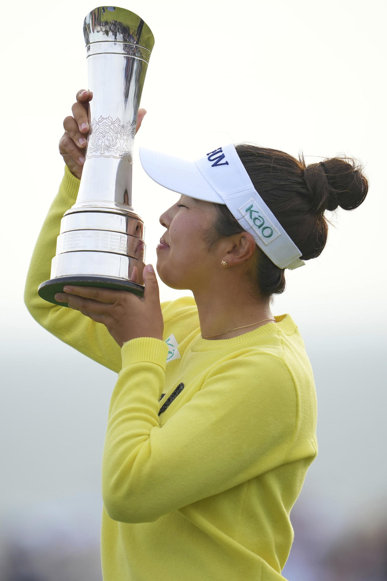 全英女子オープンの優勝トロフィーにキスをする山下美夢有（AP）
