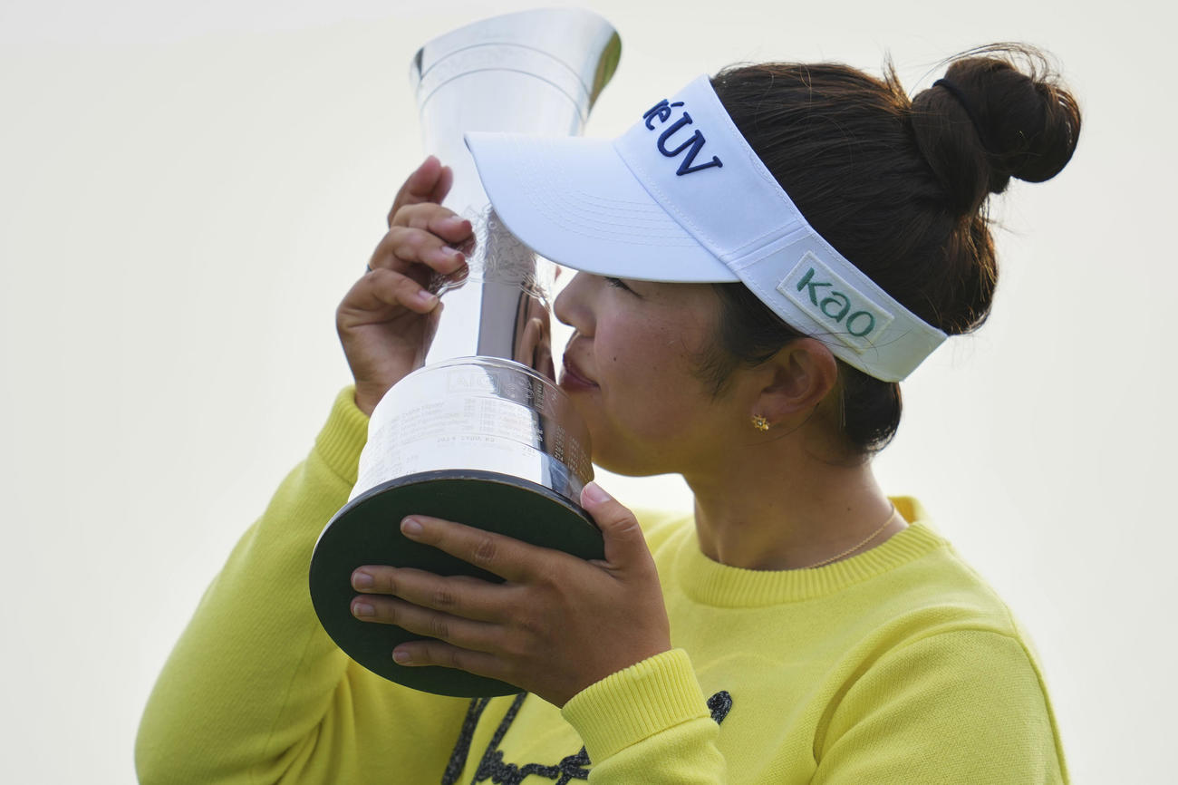 全英女子オープンの優勝トロフィーにキスをする山下美夢有（AP）