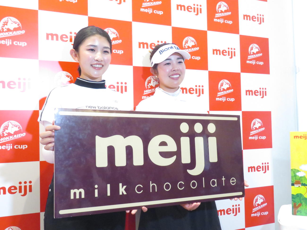 キャディーを務める妹の蘭さん（左）と並んで笑顔の山下は、全英女子オープン優勝のお祝いとして、主催の明治ホールディングスから明治製品詰め合わせを贈呈された