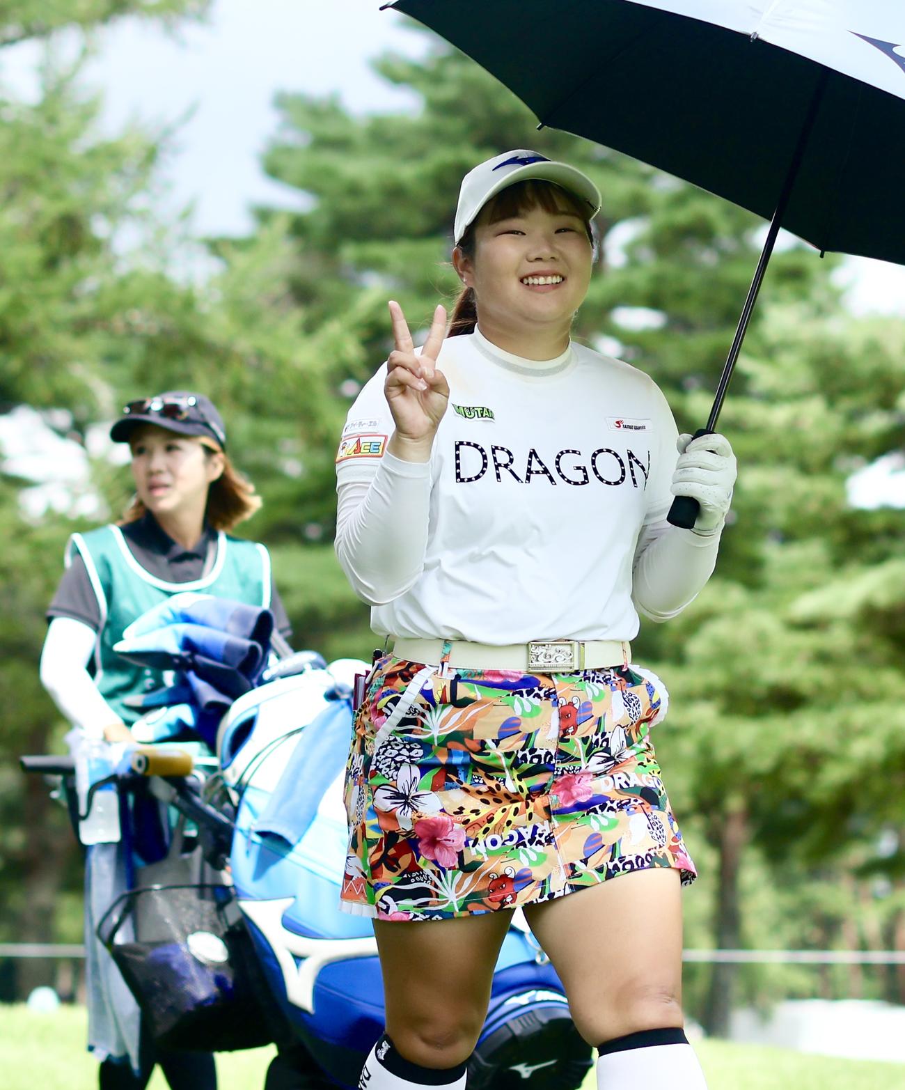 5番、ティーショットを放ち、笑顔でVサインしながら移動する寺岡（撮影・河田真司）