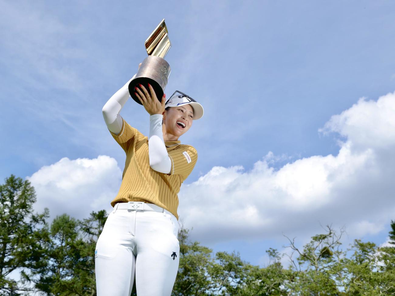 笑顔で優勝トロフィーを掲げる柏原（撮影・河田真司）