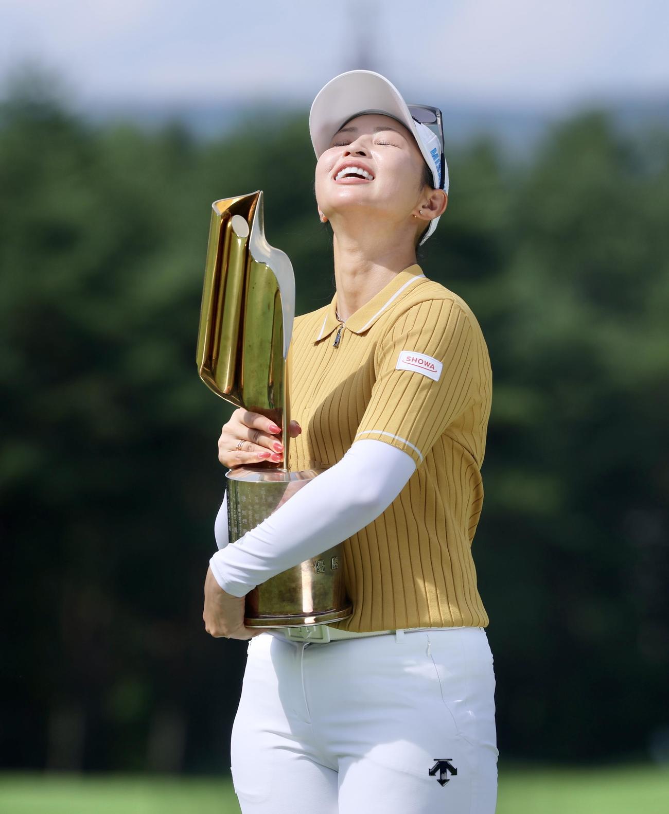 笑顔で優勝トロフィーを抱きかかえる柏原（撮影・河田真司）