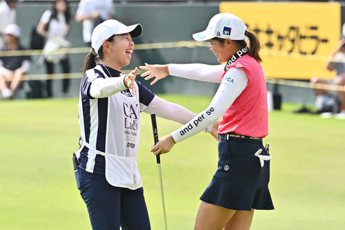 優勝を決めた桜井（右）はキャディーを務めた吉田と抱き合って喜ぶ（撮影・滝沢徹郎）