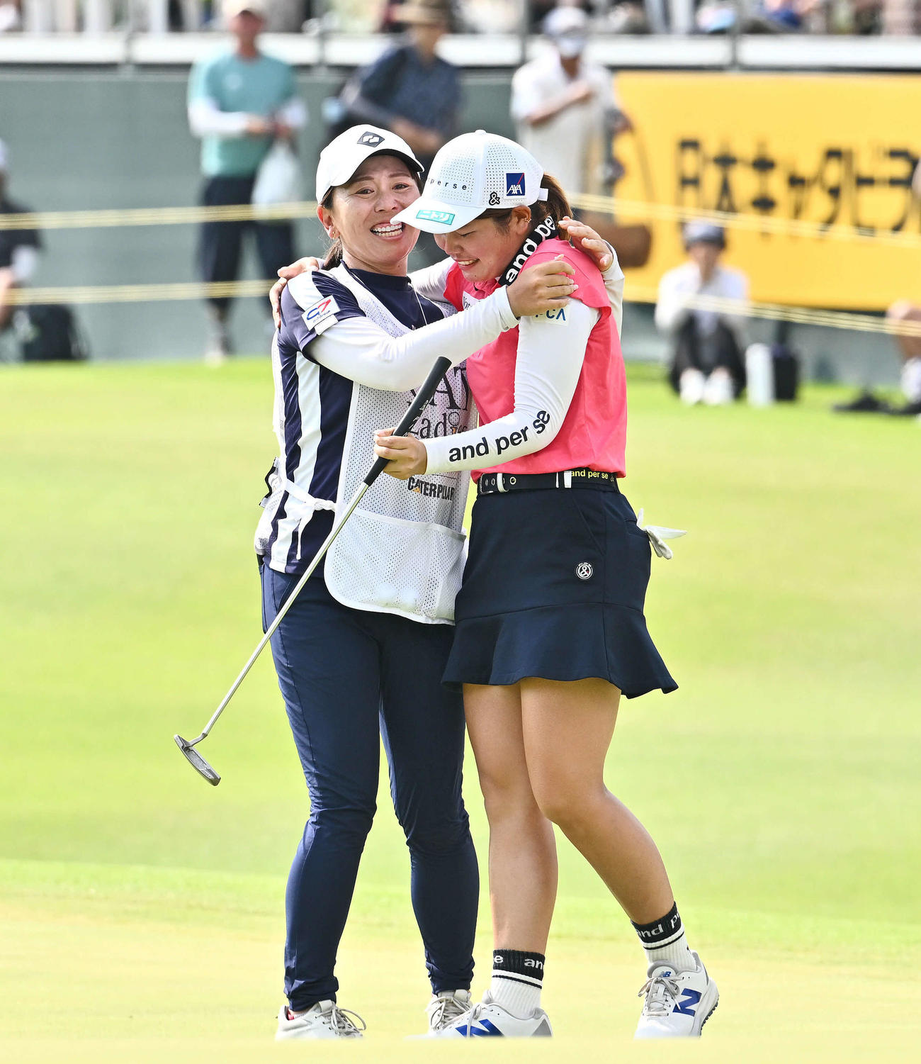 優勝を決めた桜井（右）はキャディーを務めた吉田と抱き合って喜ぶ（撮影・滝沢徹郎）