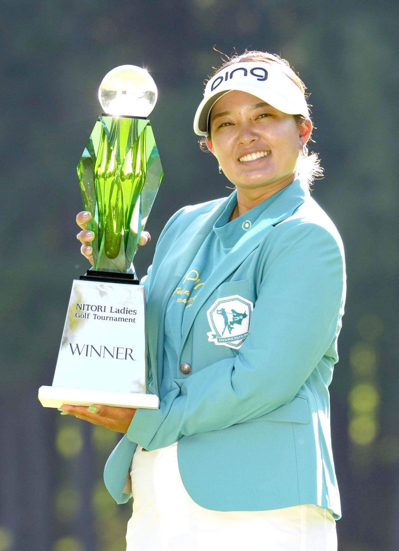 通算12アンダーで優勝し、トロフィーを手に笑顔の鈴木愛（共同）