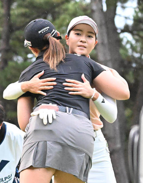 ソニー日本女子プロゴルフ選手権大会第2日、通算10アンダーで単独首位でホールアウトし、同組の渡辺彩香（手前）と健闘をたたえ合う佐藤心結（撮影・千葉一成）