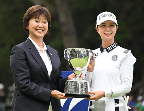 プレーオフを制してメジャー初優勝を決め、日本女子プロゴルフ協会の小林会長（左）から優勝杯を贈られ記念撮影する金沢（撮影・千葉一成）