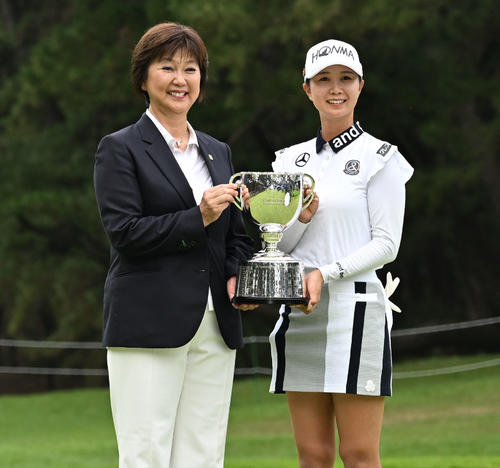 プレーオフを制してメジャー初優勝を決め、日本女子プロゴルフ協会の小林会長（左）から優勝杯を贈られ記念撮影する金沢（撮影・千葉一成）