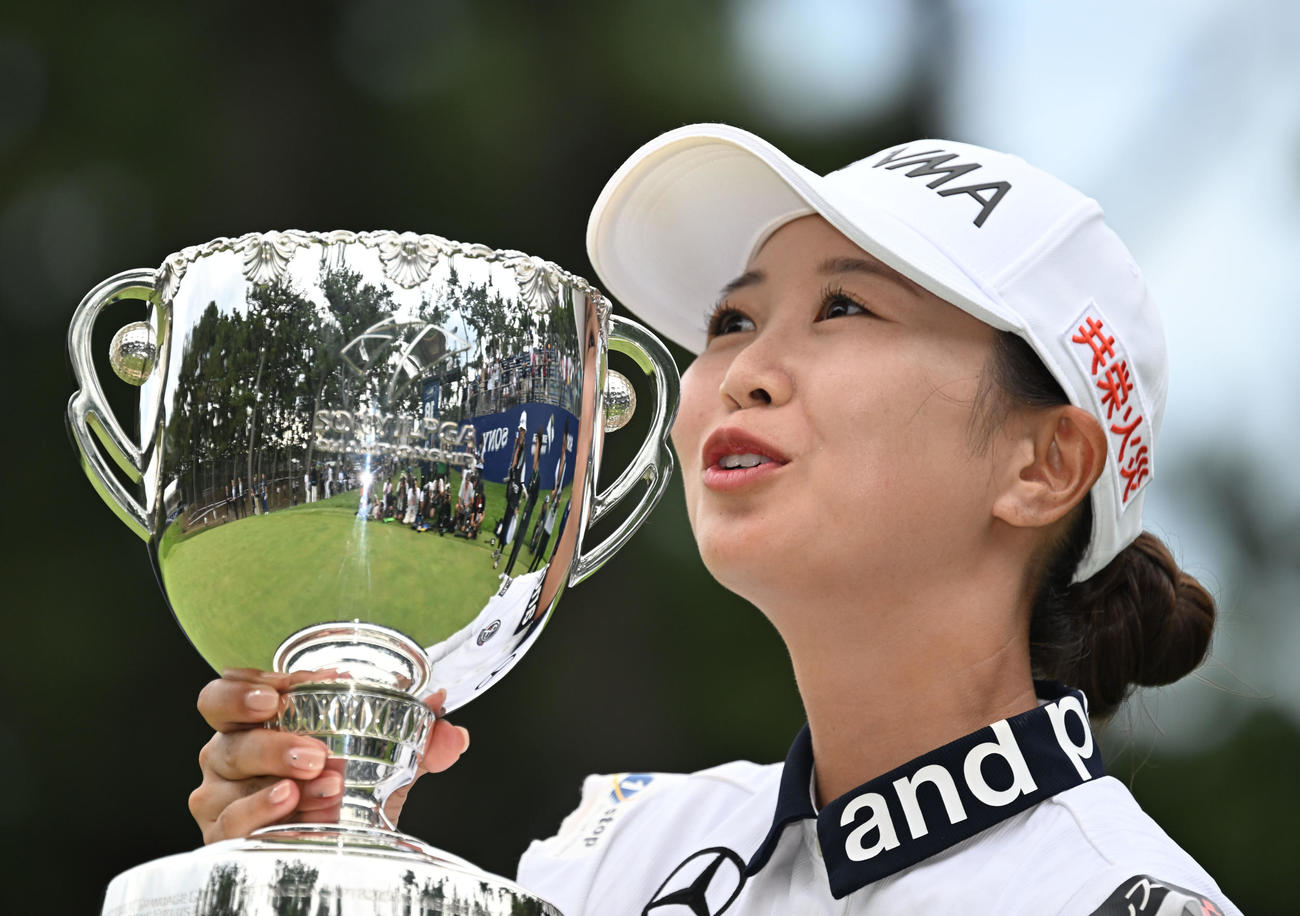 プレーオフを制してメジャー初優勝を決め、カップにキスするポーズを見せる金沢志奈（撮影・千葉一成）