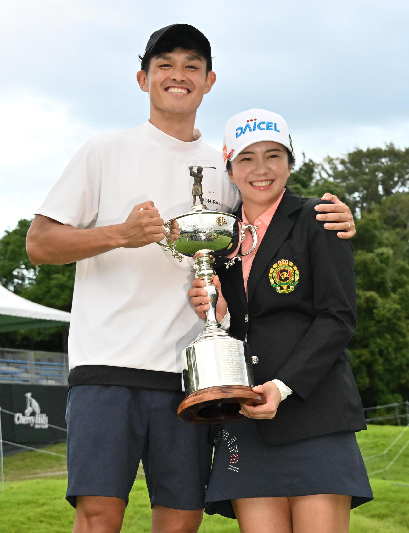 優勝トロフィーを手に笑顔を見せる堀琴音（右）、夫の高坂佳祐氏（撮影・石井愛子）