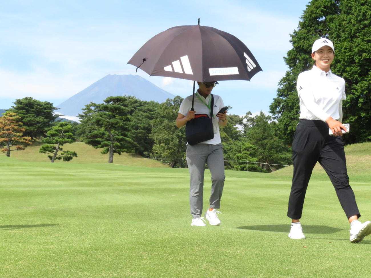 渋野日向子（右）は14番途中、雄大な富士山を背に満面の笑みを見せながらフェアウエーを歩いた