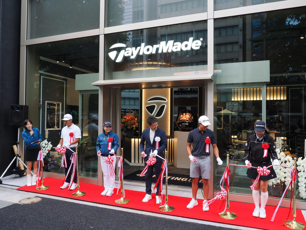 テープカットで、1人テープが切れない山路晶（右）を見つめるコリン・モリカワ（右から2人目）ら