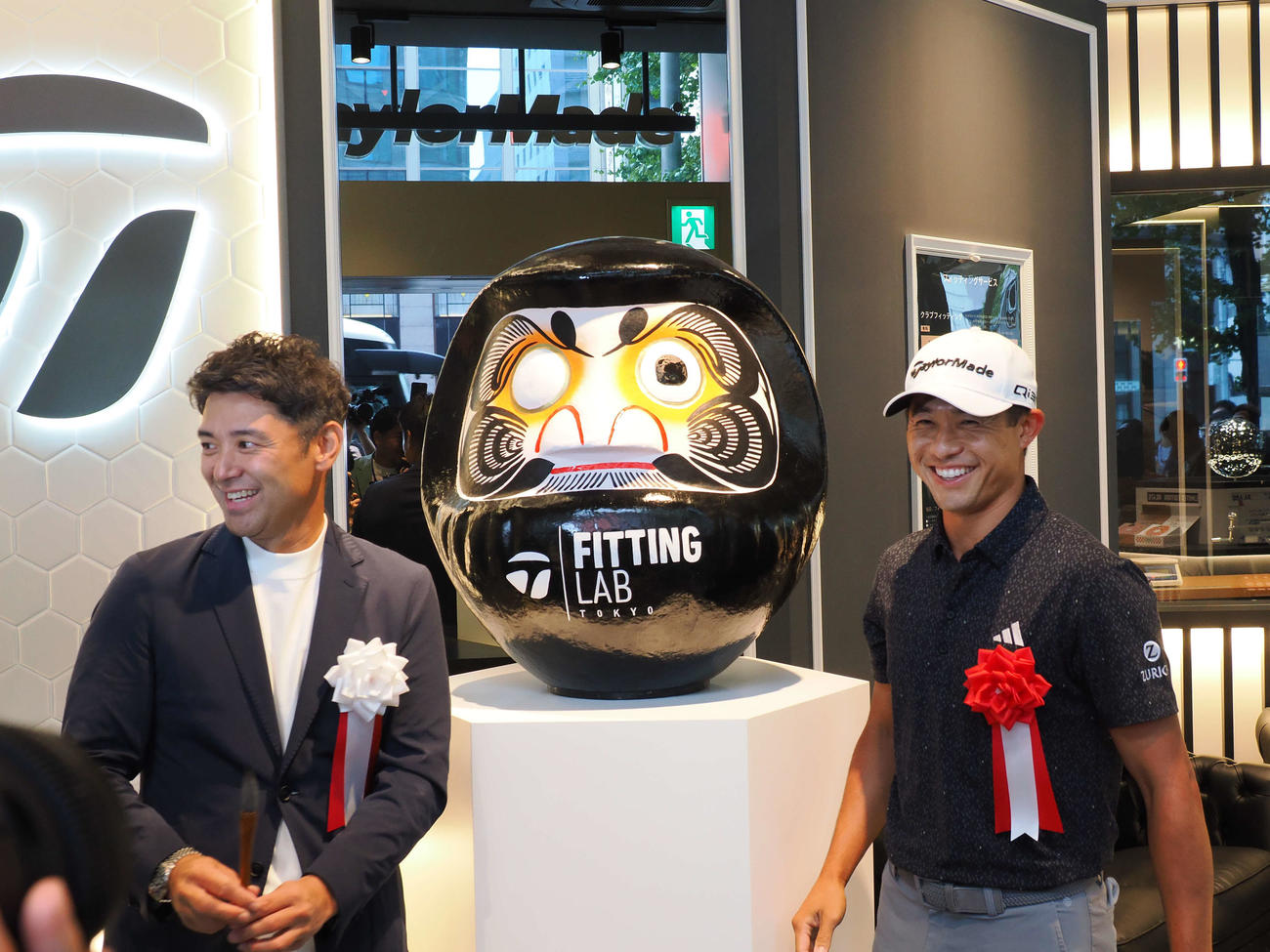 オープニングイベントで、丁寧にだるまの目入れを行ったコリン・モリカワ。左は比留間社長