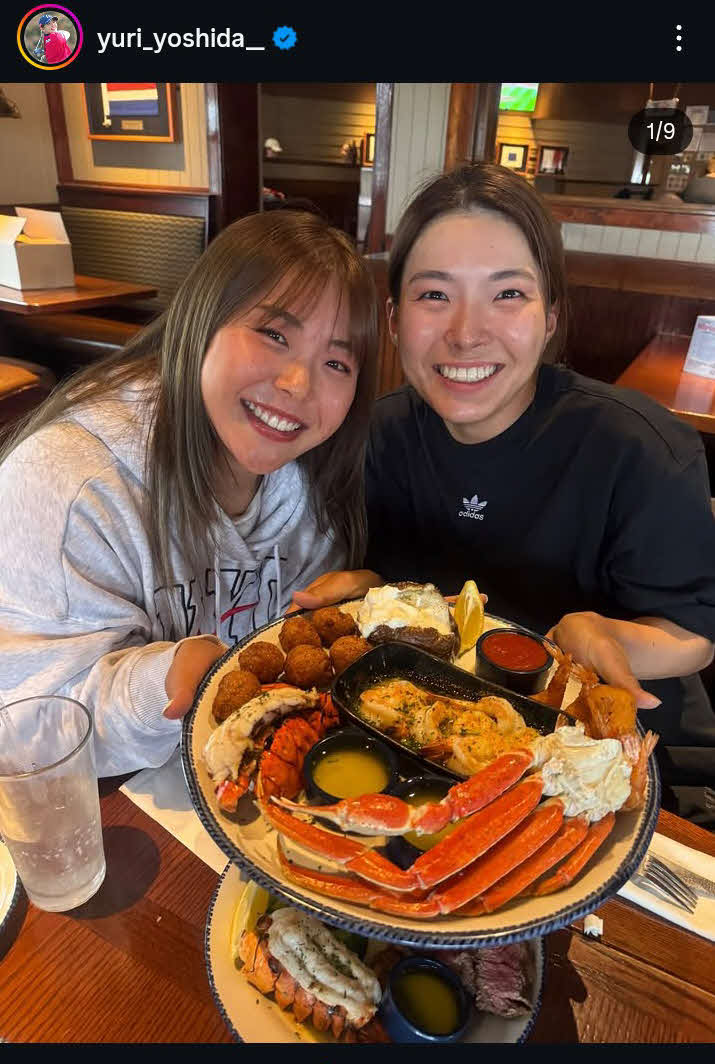 カニが盛られたプレートを持ち上げて笑顔をみせる吉田優利（左）と渋野日向子（吉田優利のインスタグラムから）