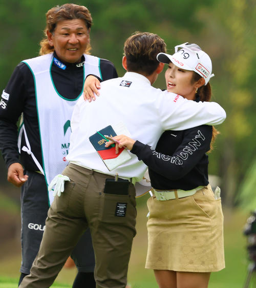 ホールアウトし岩井明（手前）とハグする佐久間（撮影・上山淳一）