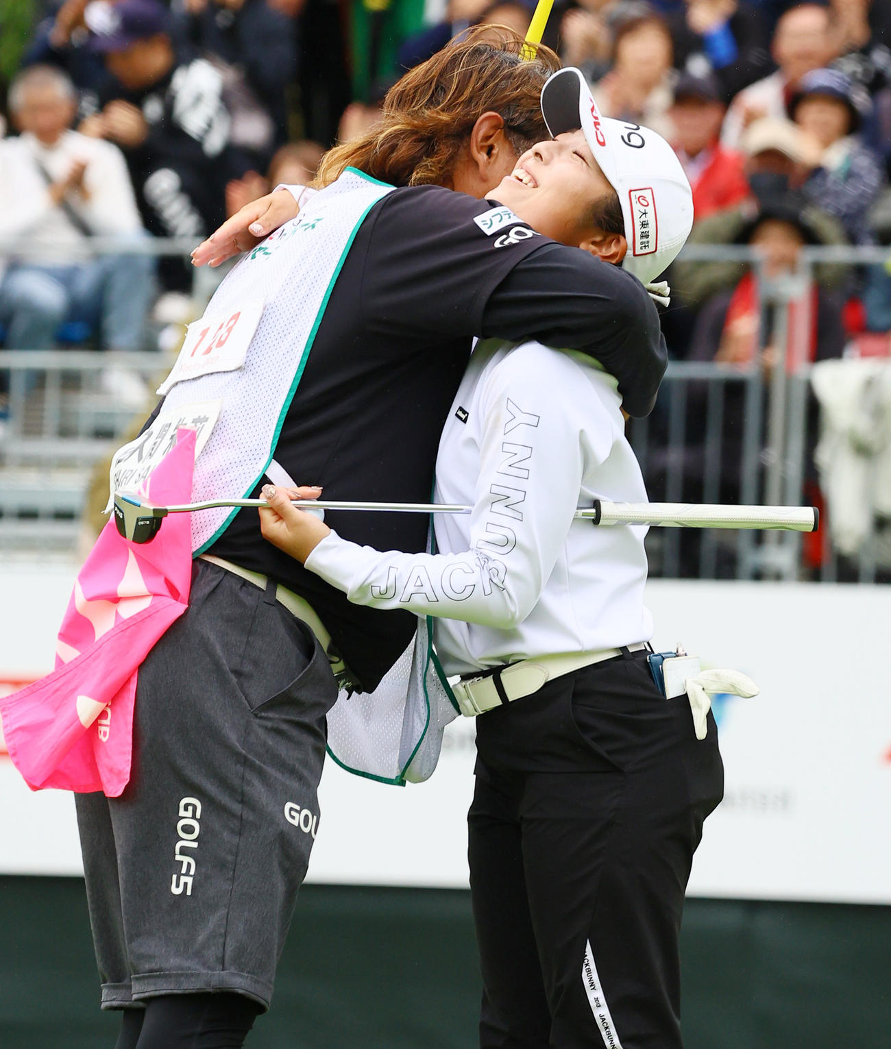 18番、ウイニングパットを決めた佐久間（右）は後藤キャディーと喜びを分かち合う（撮影・上山淳一）